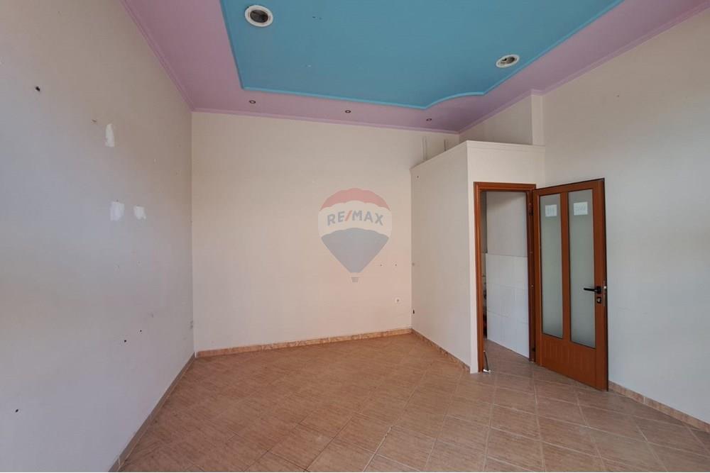 Dyqan në shitje pranë bashkisë Vlorë, me fasadë nga sheshi kryesor